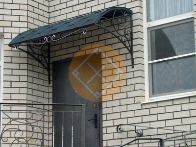 Полуарочный козырек с черной крышей к дому