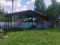 двускатный навес с крышей из металлочерепицы красного цвета